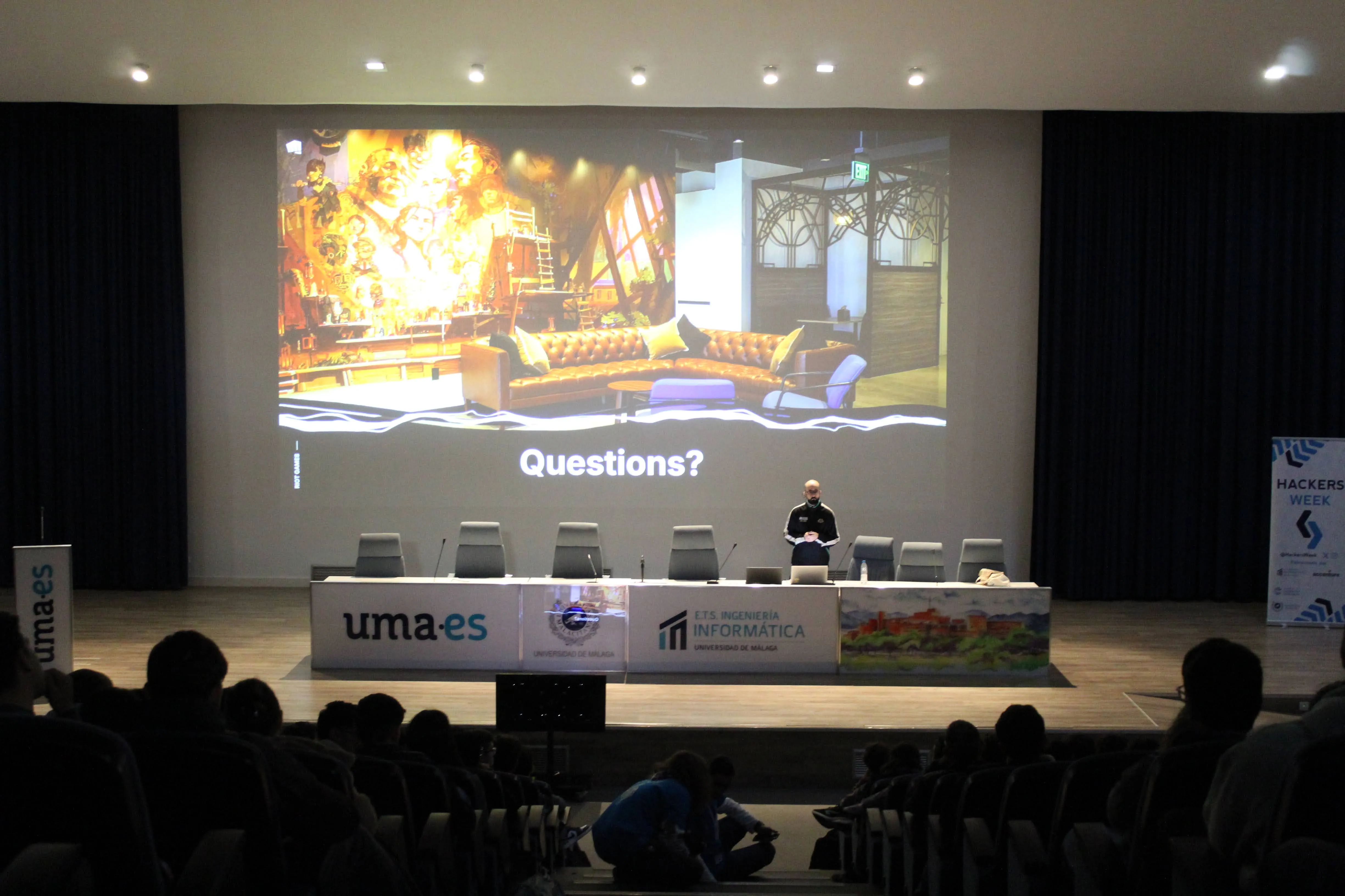 Alberto on stage at Hackers Week 2026, University of Málaga, with the audience in front.